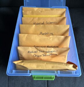 Plastic bin organizing card sorts in labeled manila envelopes